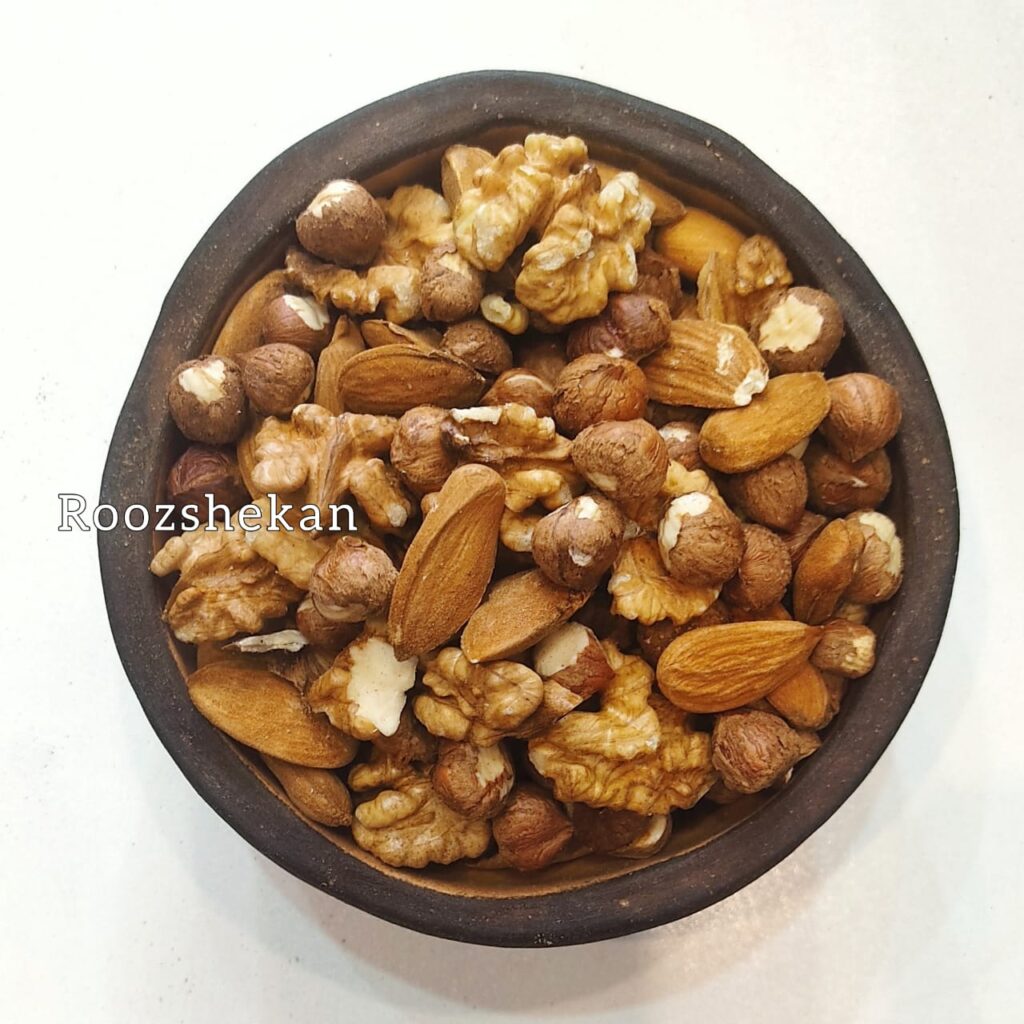 یک کاسه سرامیکی پرآجیل سه مغز ایرانی که شامل از فندق بدام درختی و گردوایرانی
